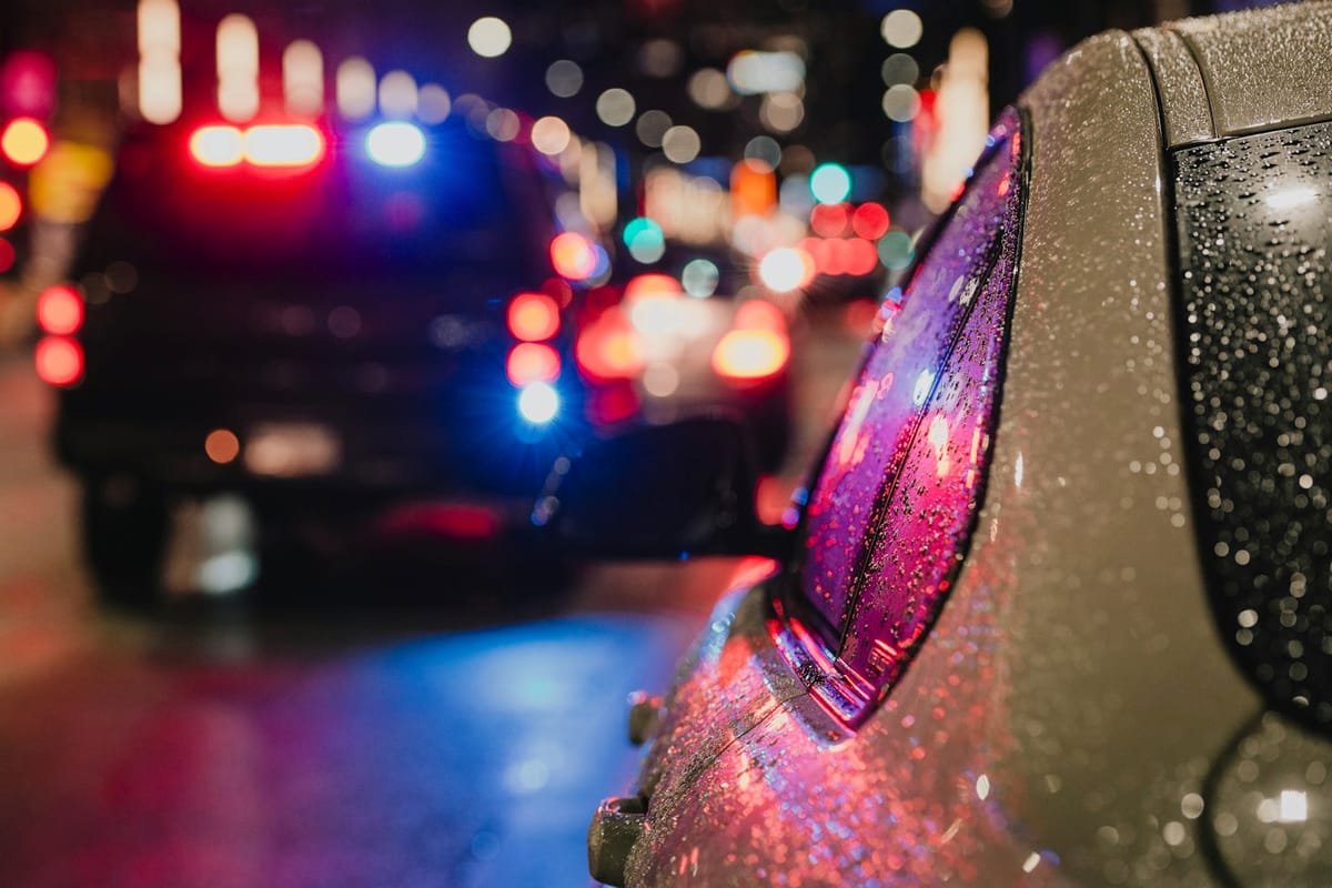 Police lights at a night traffic stop on a wet city street